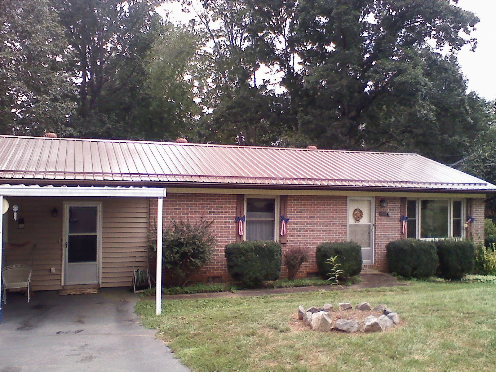Bronze metal roof and carport on a brick ranch home — Roof Repair work by our crew in Malabar