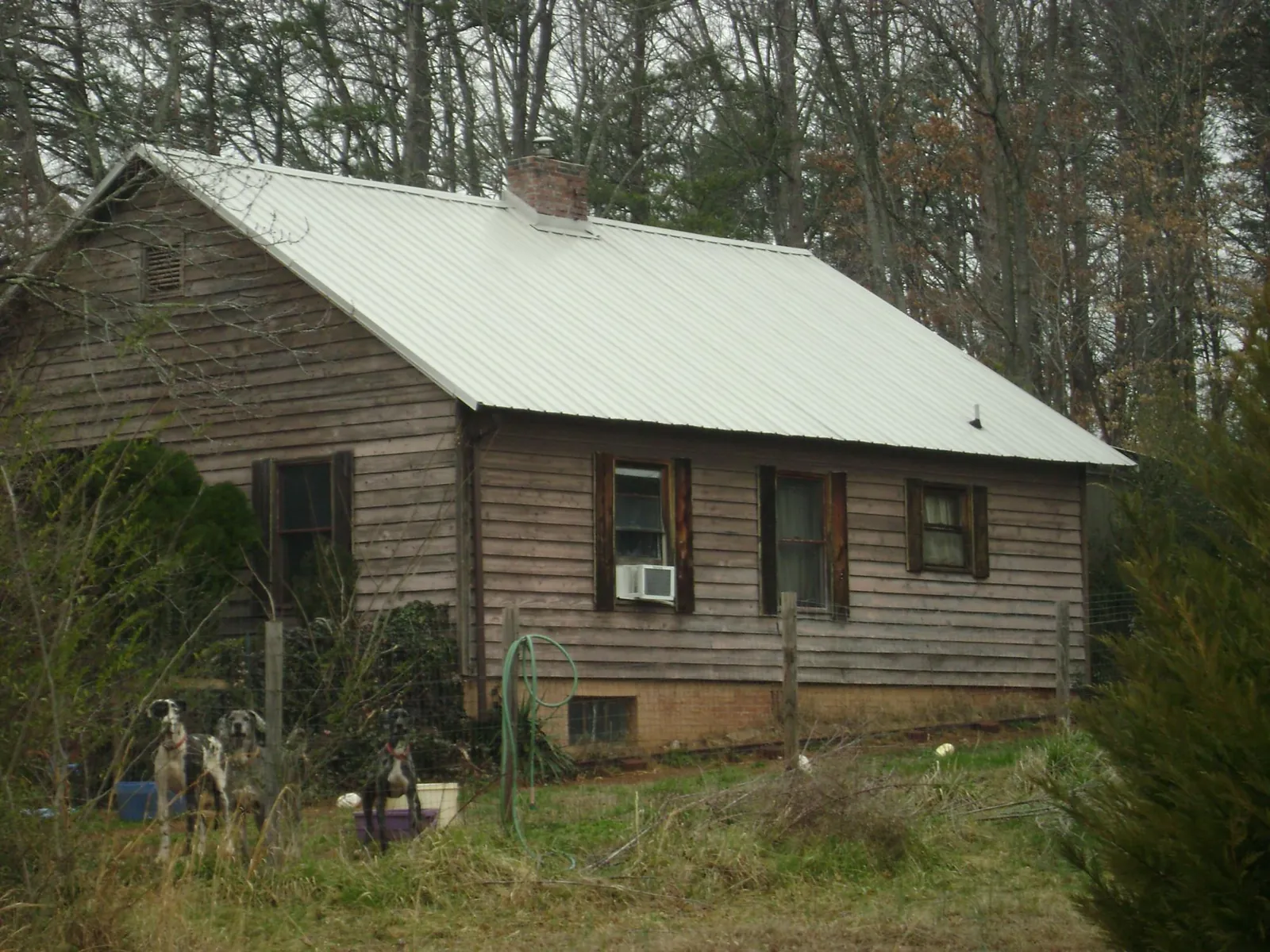 White metal roof on an old wood sided farmhouse, from a Metal Roof Installation job in Malabar